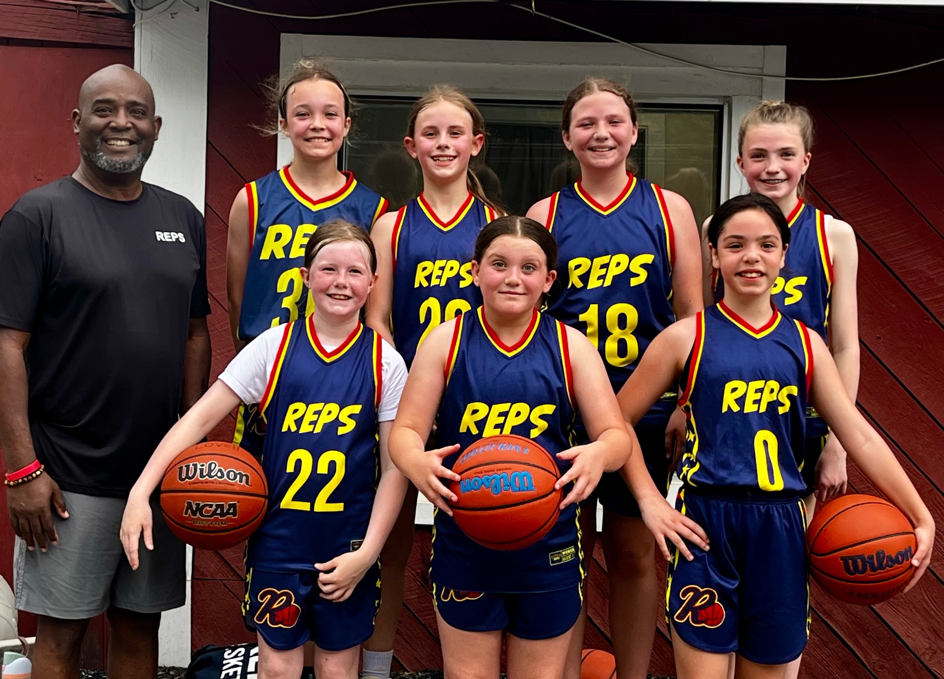 REPS girls basketball players with Coach Isiah Anderson